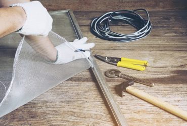 Man is working with mosquito wire screen installation